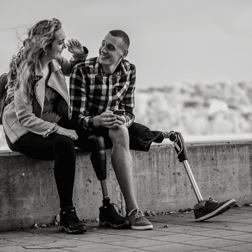 A man and a woman with prosthetic legs sitting.