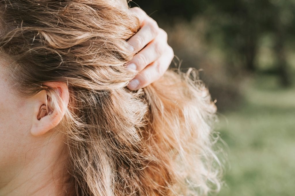 small intra channel hearing aid in the ear of a woman