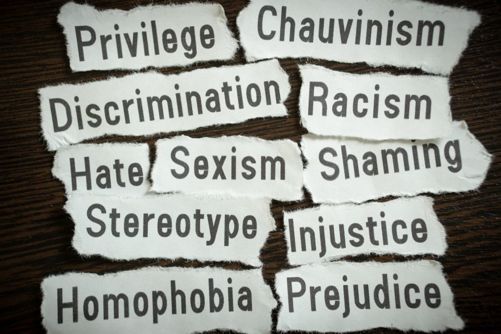 Wörter auf einem Papier einschließlich Privileg, Diskriminierung, Stereotyp, Rassismus