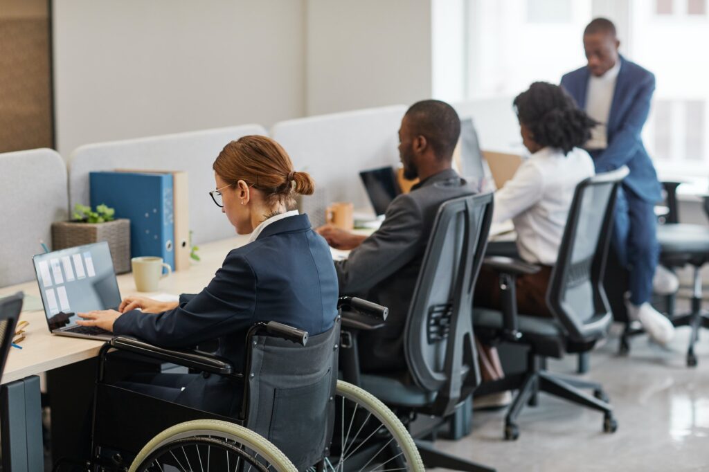 Woman in Wheelchair Working with Colleagues
