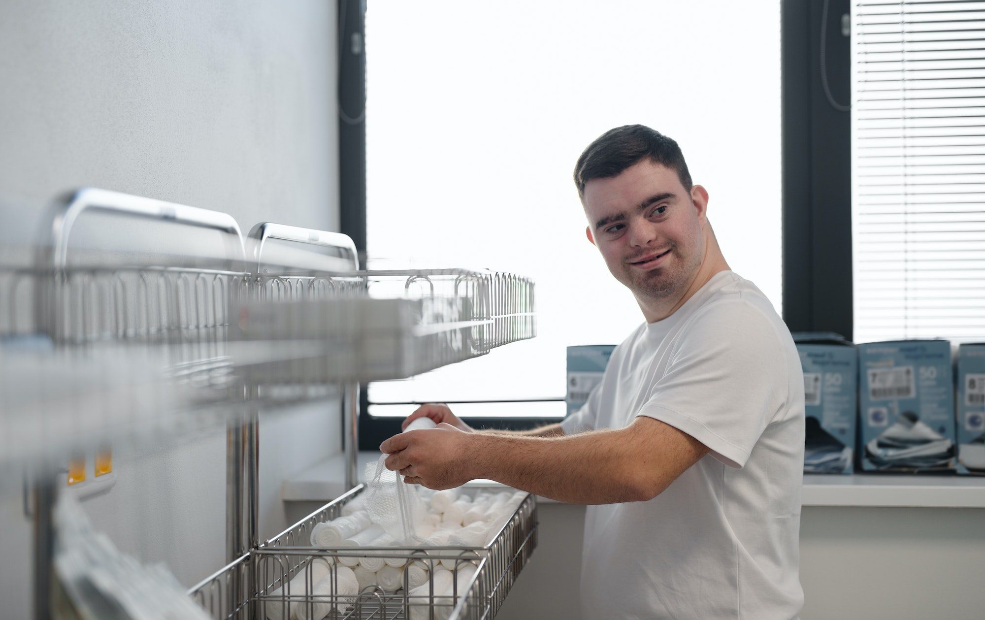 Young man with down syndome working in hospital as orderly. Concept of integration people with
